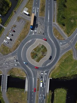 Aerial top down view of a traffic roundabout on a main road in an urban area of the Netherlands