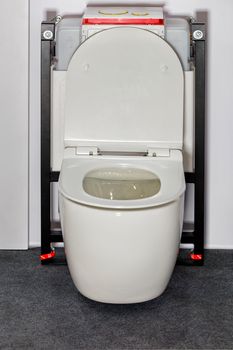 White toilet with a modern concealed wall system and flush mechanism.