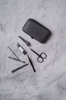 Set of manicure, pedicure tools and accessories with case, stone concrete background, top view