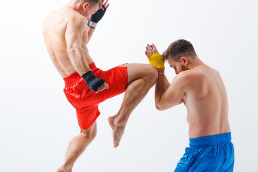 Two men boxers fighting muay thai kick boxing white background