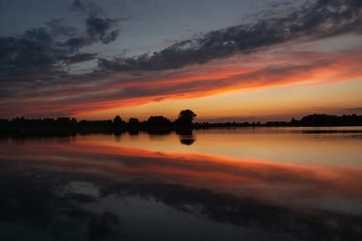 Reflection of colorful clouds in the lake water after sunset