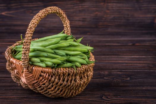 Fresh green beans on wooden table on rustic wooden background, selective focus