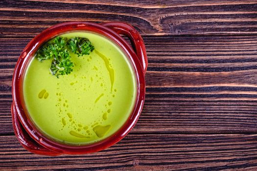 Fresh asparagus creamy soup and ingredients on wooden table on rustic wooden background, selective focus