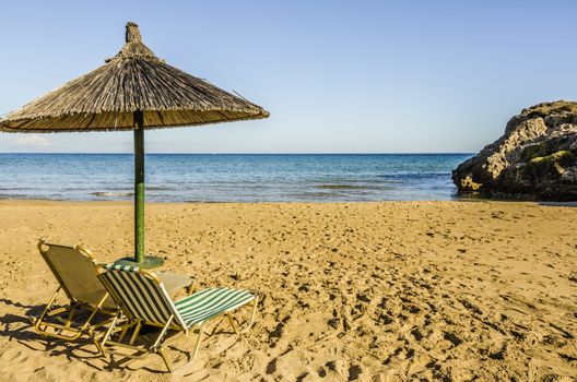 golden sand lounge chairs and parasol on the beaches of the island of zakynthos greece