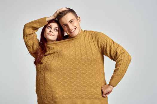 couple in yellow sweater posing against light background cropped view. High quality photo