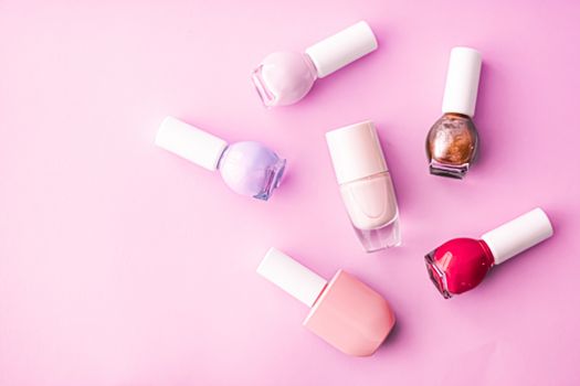 Nail polish bottles on pink background, beauty branding