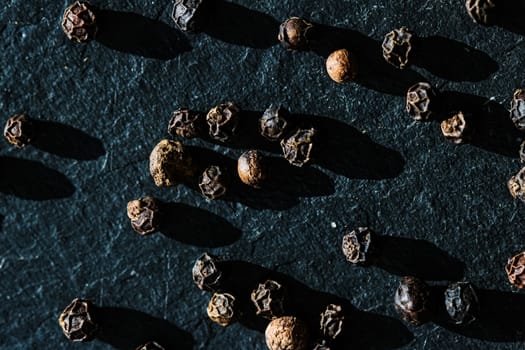 Black pepper closeup on luxury stone background as flat lay, dry food spices and recipe ingredients