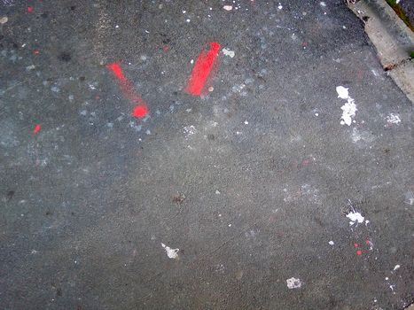 Multi-colored paint drops on the asphalt on the street.