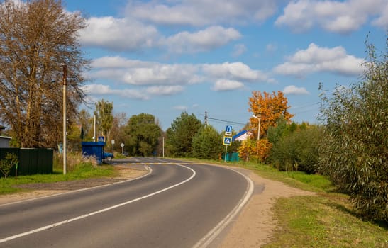 Winding asphalt rural road on an autumn day.