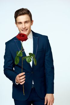 A man in a suit with a rose in his hands a gift date light background. High quality photo