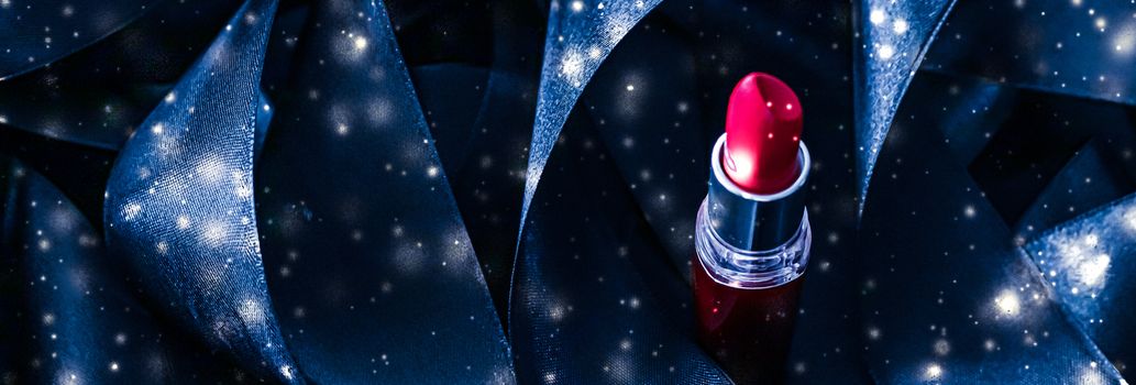 Red lipstick on blue silk and shiny glitter background, luxury make-up and beauty cosmetics