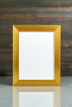 Picture golden frame mock up and Artificial flower vase bouquet over table with wood wall background