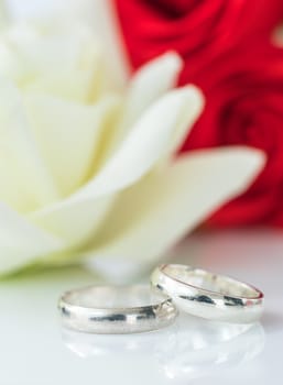 Close up red rose and wedding ring on white background, Wedding concept with roses and ring