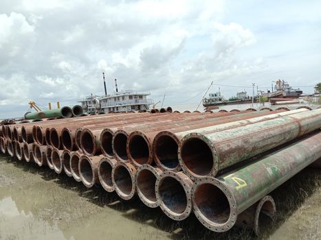 old Iron pipe stock near of river for sand collection