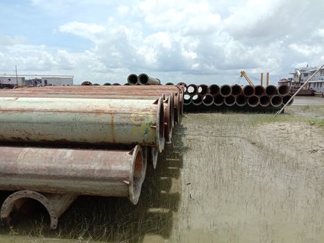 old Iron pipe stock near of river for sand collection