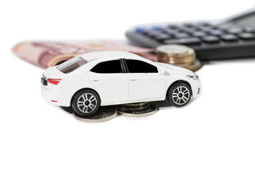 white car model with coins and calculator blur background concept saving money for car or insurance for car