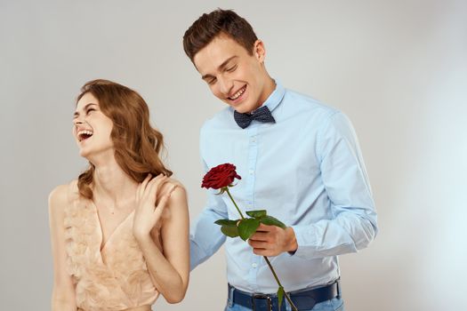 Cheerful young couple romance embrace relationship red rose lifestyle light background. High quality photo