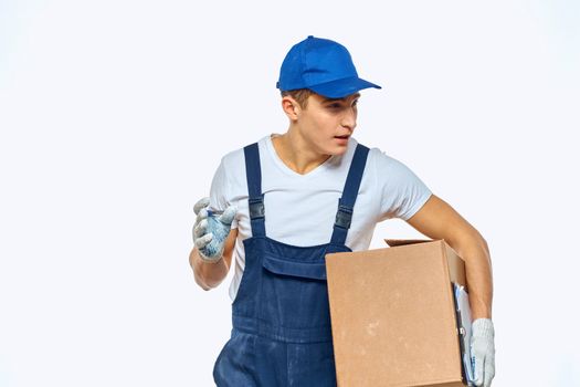 Man worker with box in hands delivery loading service work light background. High quality photo