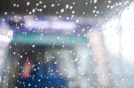 View from inside a car being washed at a car wash from the driver seat. Auto inside carwash from interior. Car windshield cleaning. Automatic conveyorized tunnel vehicle wash.