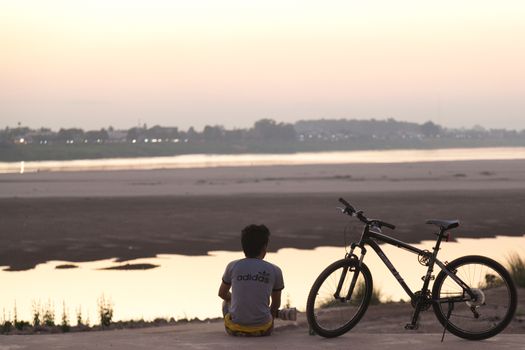 Mekong River, Vientiane, Laos at sunset, with silhouettes reflecting in water looking across the border to Thailand . High quality photo