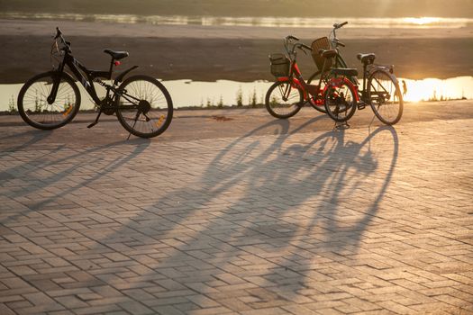 Mekong River, Vientiane, Laos at sunset, with bicycles and shadows . High quality photo