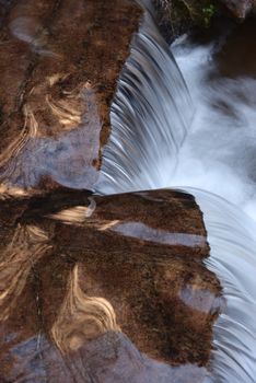 Beautiful waterfall streaming over red colored bedrock in the Left Fork North Creek, Zion National Park.