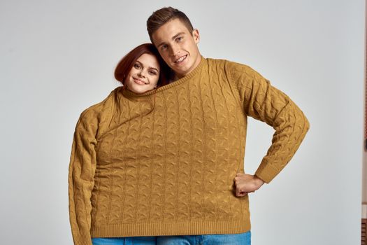 couple in yellow sweater posing against light background cropped view. High quality photo