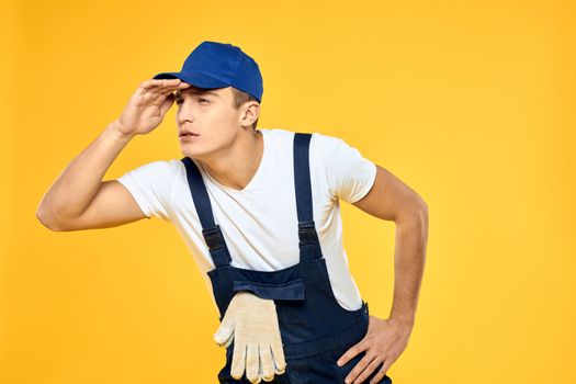 Man in working uniform emotions rendering service delivery service yellow background. High quality photo