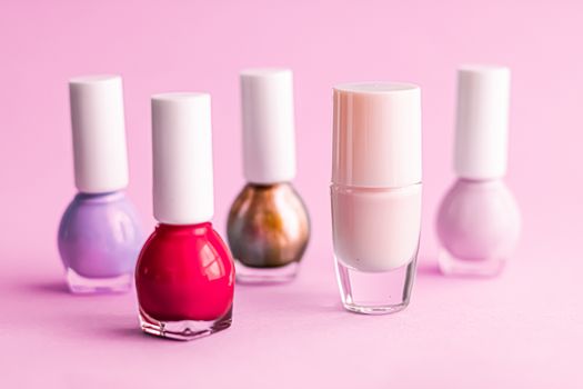 Nail polish bottles on pink background, beauty branding