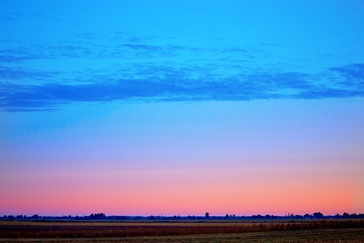 Early autumn dawn over an agricultural field