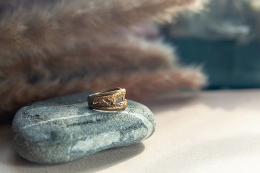 trendy vintage cast brass ring. jewelry womens ring abstract drawing closeup on a gray natural stone with shaddows
