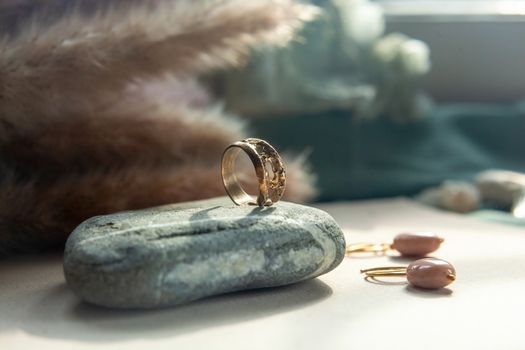 trendy vintage cast brass ring. jewelry womens ring abstract drawing closeup on a gray natural stone with shaddows