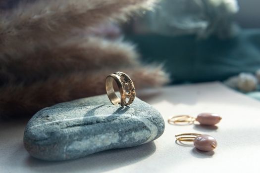 trendy vintage cast brass ring. jewelry womens ring abstract drawing closeup on a gray natural stone with shaddows