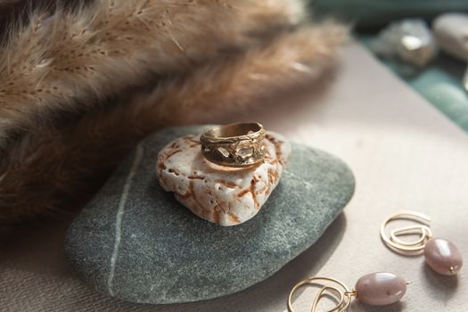 trendy vintage cast brass ring. jewelry womens ring abstract drawing closeup on a gray natural stone with shaddows