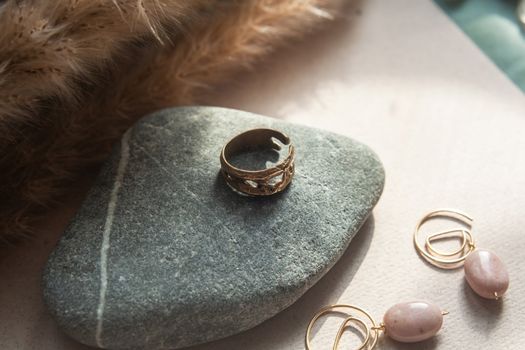trendy vintage cast brass ring. jewelry womens ring abstract drawing closeup on a gray natural stone with shaddows