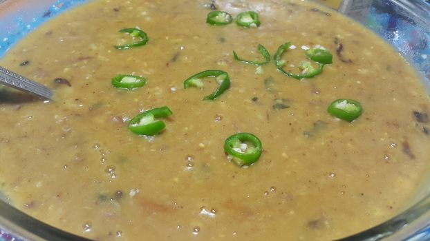 Delicious traditional haleem dish with green pepper  in a bowl, for dinner / lunch. Food background