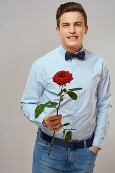 romantic man with red rose and light shirt pants suit. High quality photo