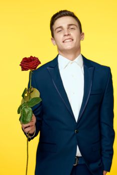 Gentleman in classic suit on yellow background with red rose romance cropped view. High quality photo