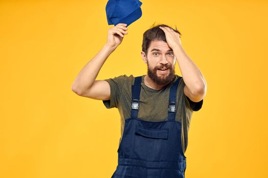 Worker man in uniform worker service yellow background emotion. High quality photo