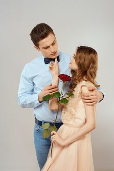 Young couple romance hug relationship dating red rose light studio background. High quality photo