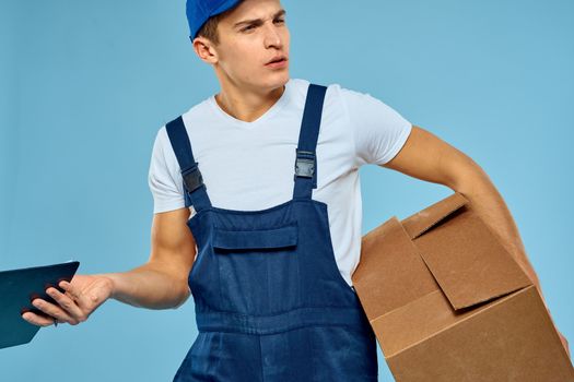 Man worker with cardboard box delivery loader lifestyle blue background. High quality photo