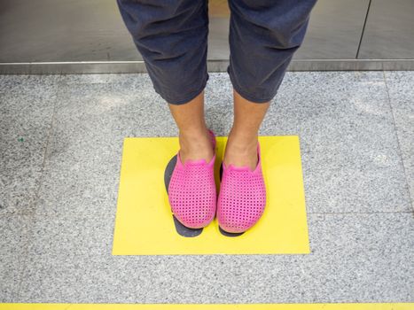 Man feet standing on Own position inside the elevator To maintain the distance within the elevator. The concept of keeping social distance