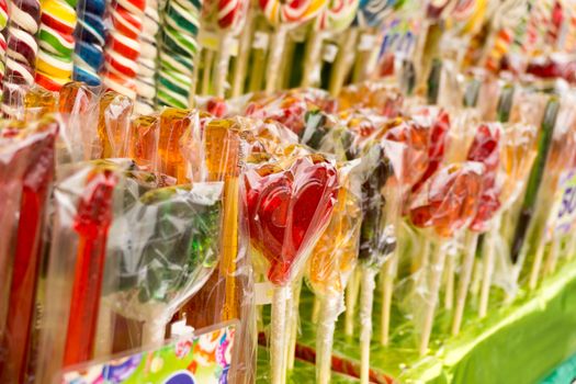 Counter with multicolored sweet lollipops of different shapes