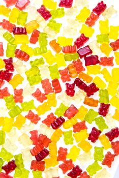 Heap of various multicolored gummy bears candies isolated on a white background