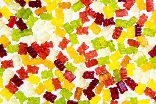 Heap of various multicolored gummy bears candies isolated on a white background