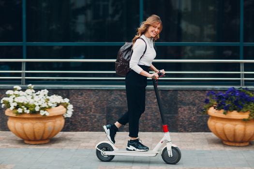 Young woman with electric scooter at the city.