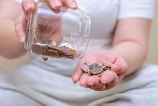 Save money and account banking for finance concept, Hand with coin bottle blurred background