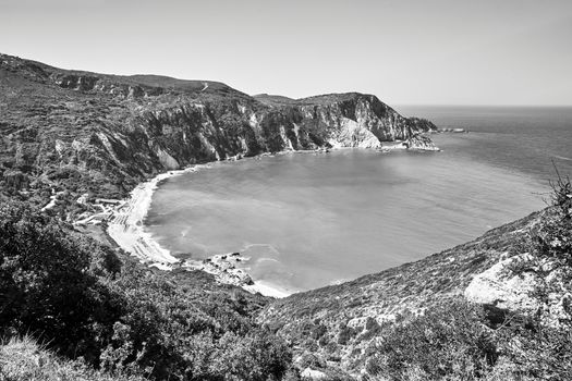 Rocky coast and beach at Petani Bay on the island of Kefalonia in Greece, black and white