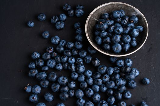 Blueberry antioxidant organic superfood in ceramic bowl concept for healthy eating and dieting nutrition Top view on dark black background