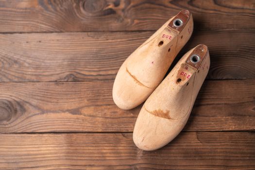 Leather samples for shoes and wooden shoe last on blue wooden table. Designer furniture clothes. Shoe maker workspace.